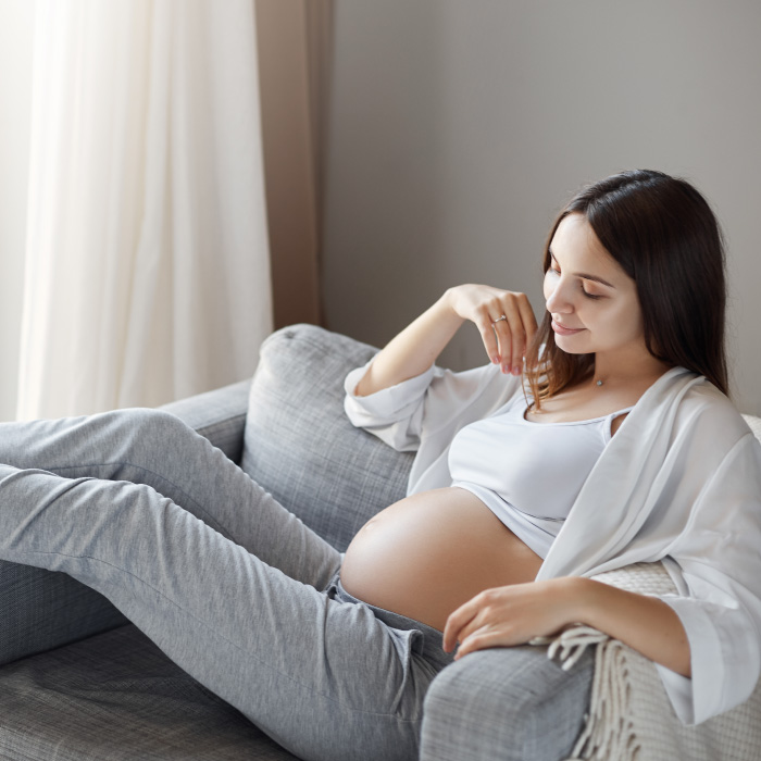 mujer-joven-embarazada-recostada-en-un-sillon-pregnant-young-woman-lying-in-the-sofa