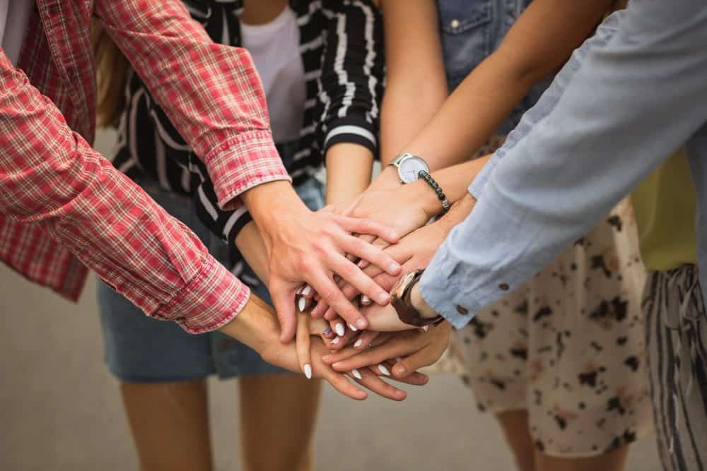 Manos de mujeres unidas una sobre otra. Women's hands joined one on top of the other.