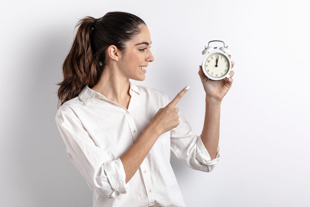 mujer-sonriente-señalando-reloj